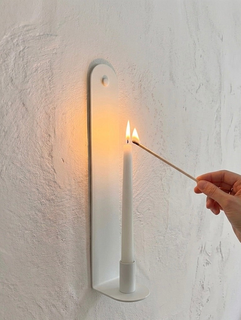 Bone White Skinny wall sconce by Nomad Studio with illuminated candle.