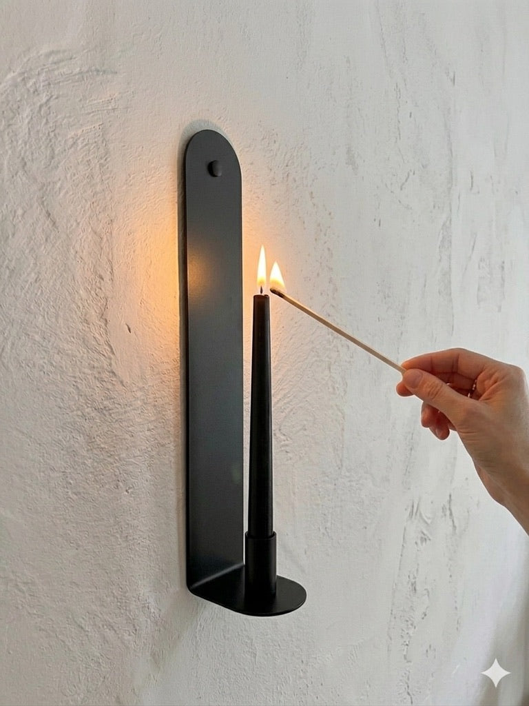 The Skinny powder-coated steel wall sconce in Black Ink, lit candle detail, Nomad Studio