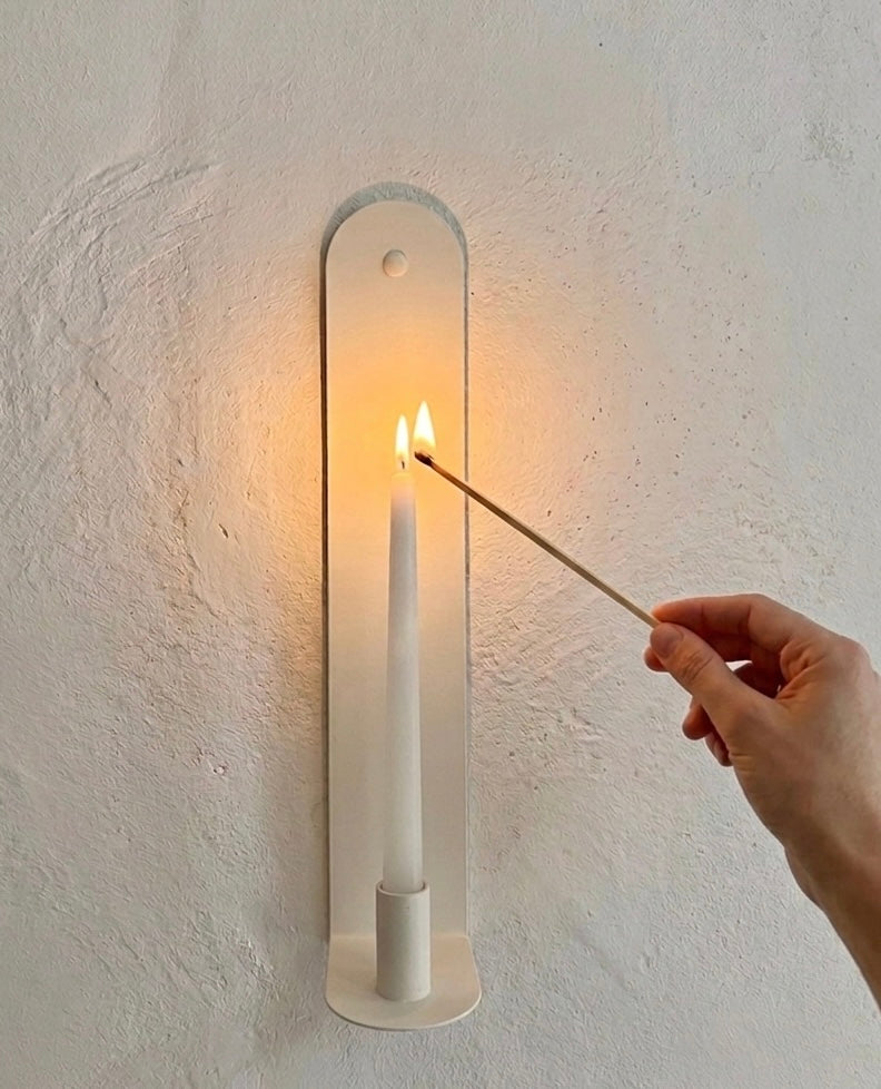 The Skinny wall sconce in Bone White with illuminated candle.